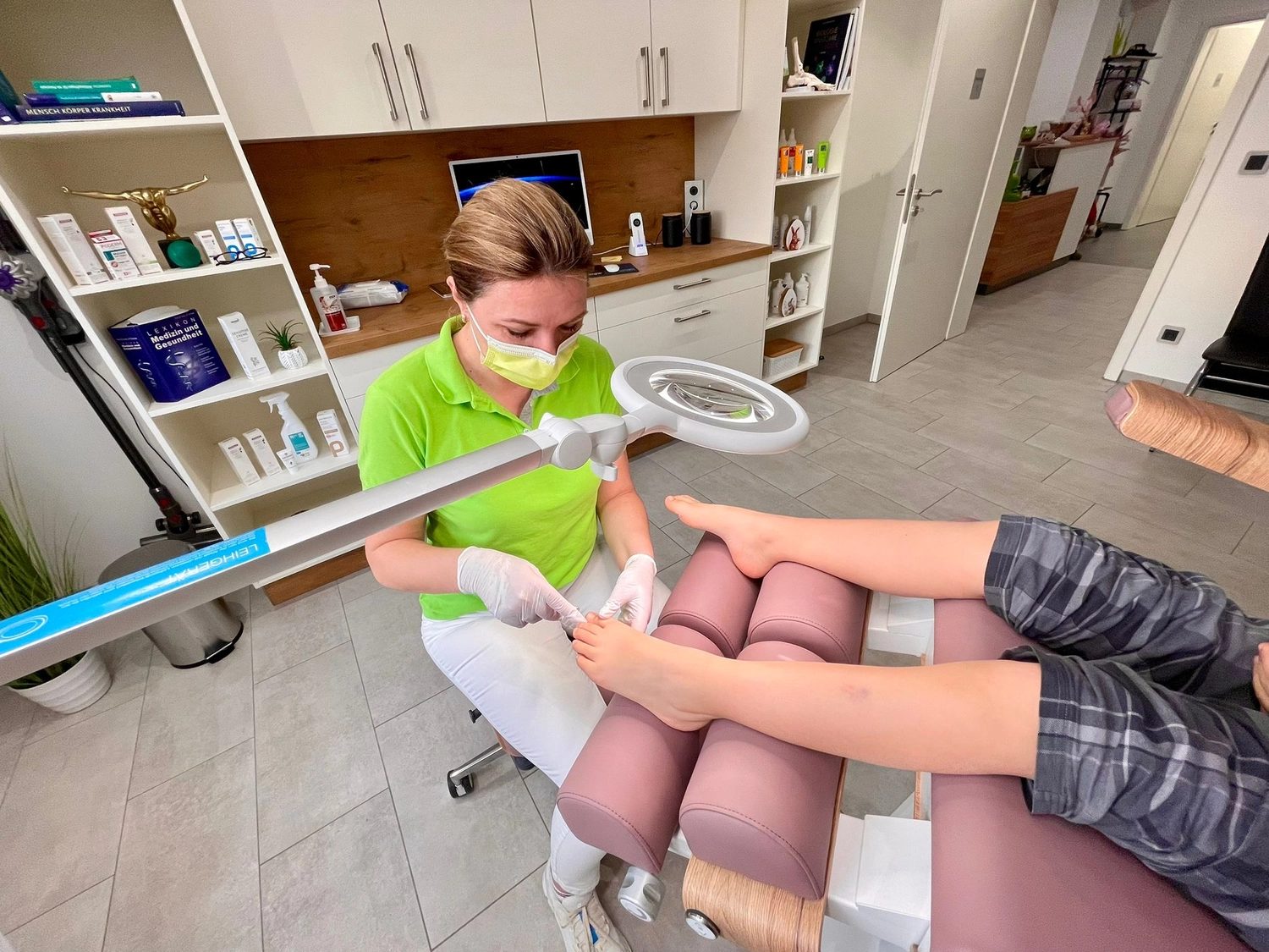 Praxis für Podologie Ramona Herczeg - Medizinische Fußbehandlung - Ramona Herczeg führt eine professionelle Fußbehandlung bzw. Pediküre an den Füßen einer Kundin durch.