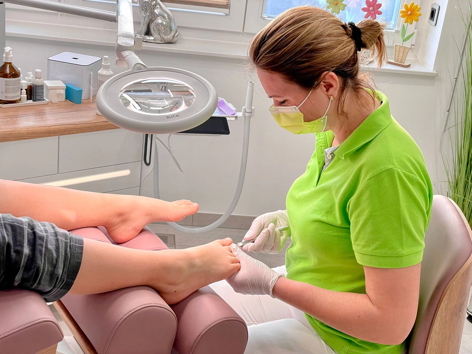 Praxis für Podologie Ramona Herczeg - Medizinische Fußbehandlung - Ramona Herczeg führt eine professionelle Fußbehandlung bzw. Pediküre an den Füßen einer Kundin durch.